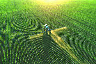 Tractor spray fertilizer on green field drone high angle view, agriculture background concept.