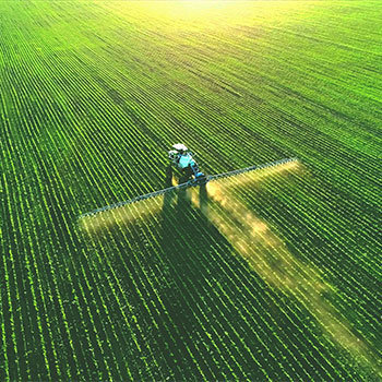 Tractor spray fertilizer on green field drone high angle view, agriculture background concept.